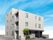 白を基調とした3階建ての建物は一部4階建てで建物の周りには草木や花が植えられている。