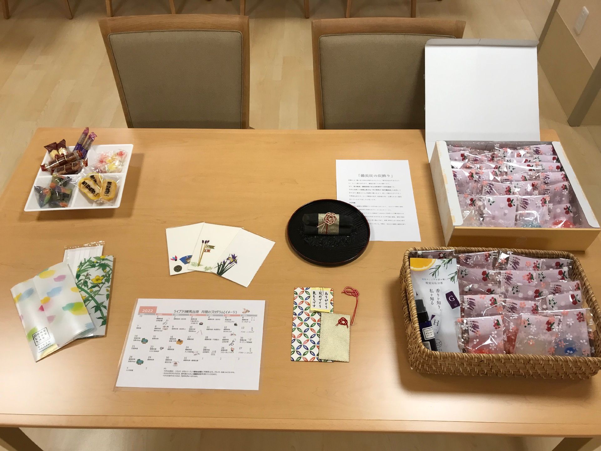 高齢者2名とスタッフが手を握りながら談笑している様子。施設内の会話の一画面