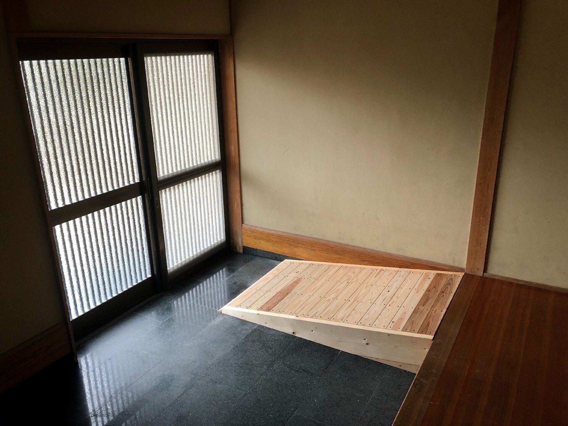 高齢者の方にタオルをかけてマッサージしているスタッフと振り返りながら会話する女性の様子