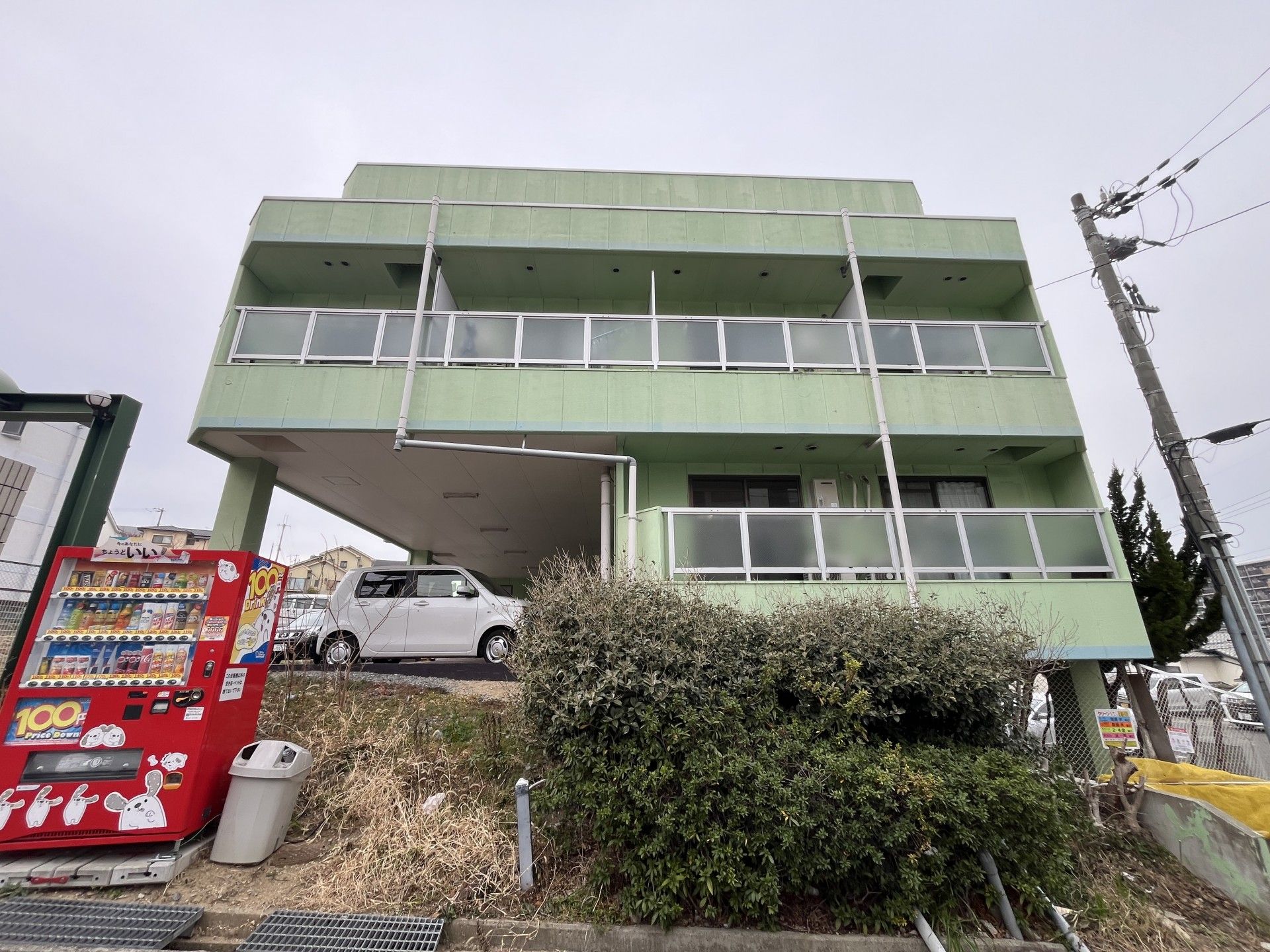 緑色の建物と自動販売機