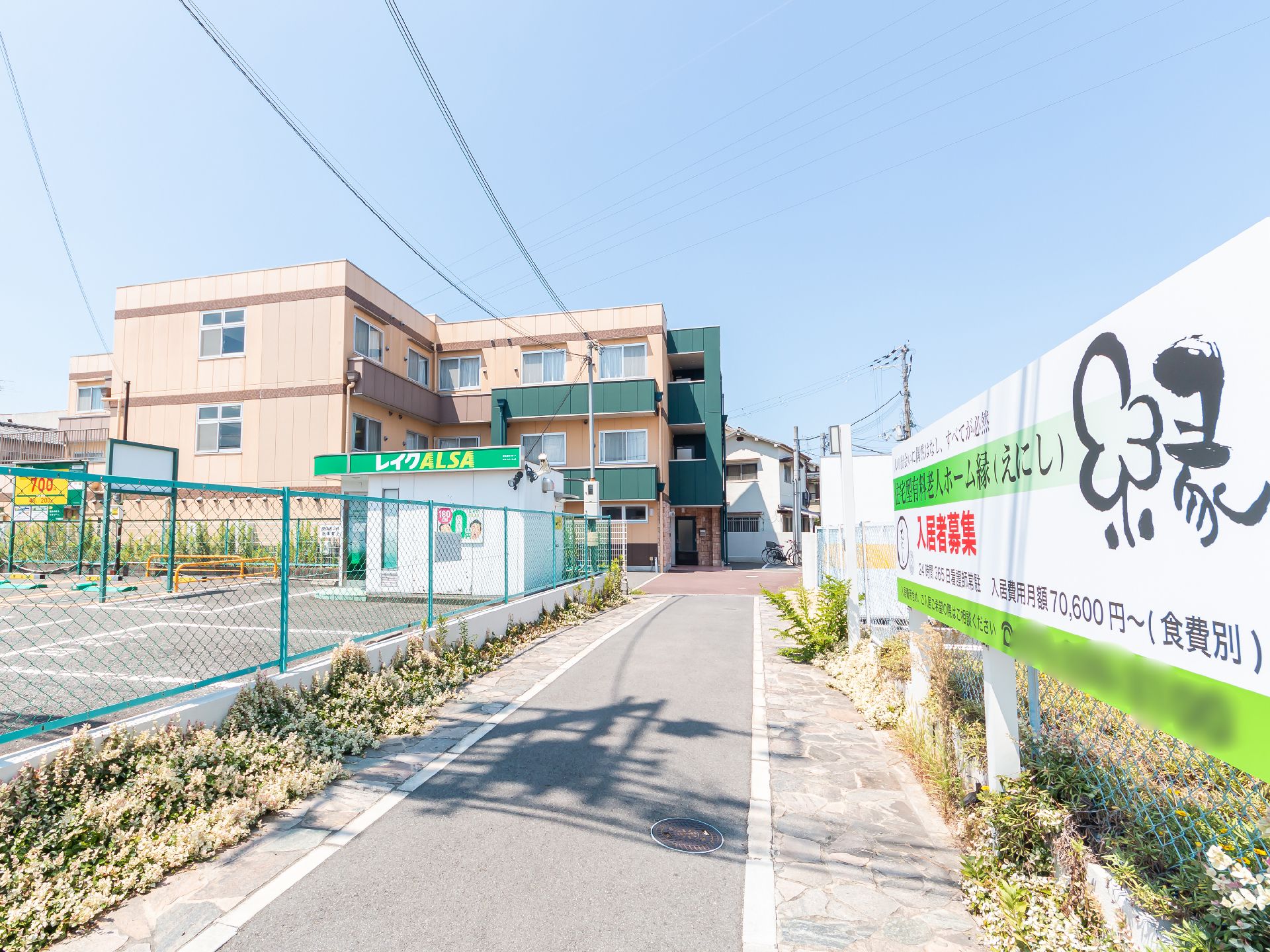 車いすに乗った女性を押す家族の男性とそこに寄り添う介護スタッフの様子
