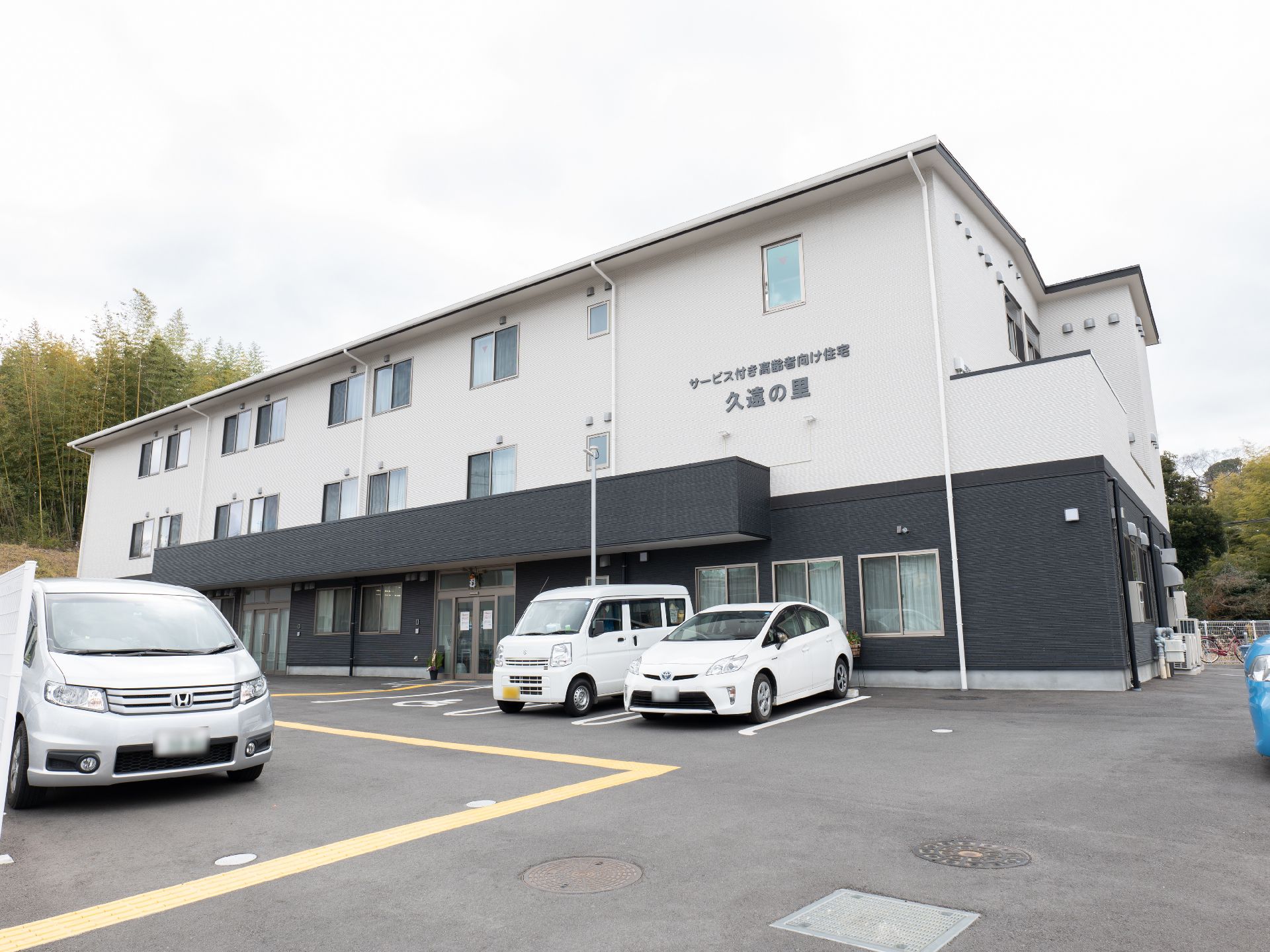 駐車場とスロープが設置してある介護施設の外観