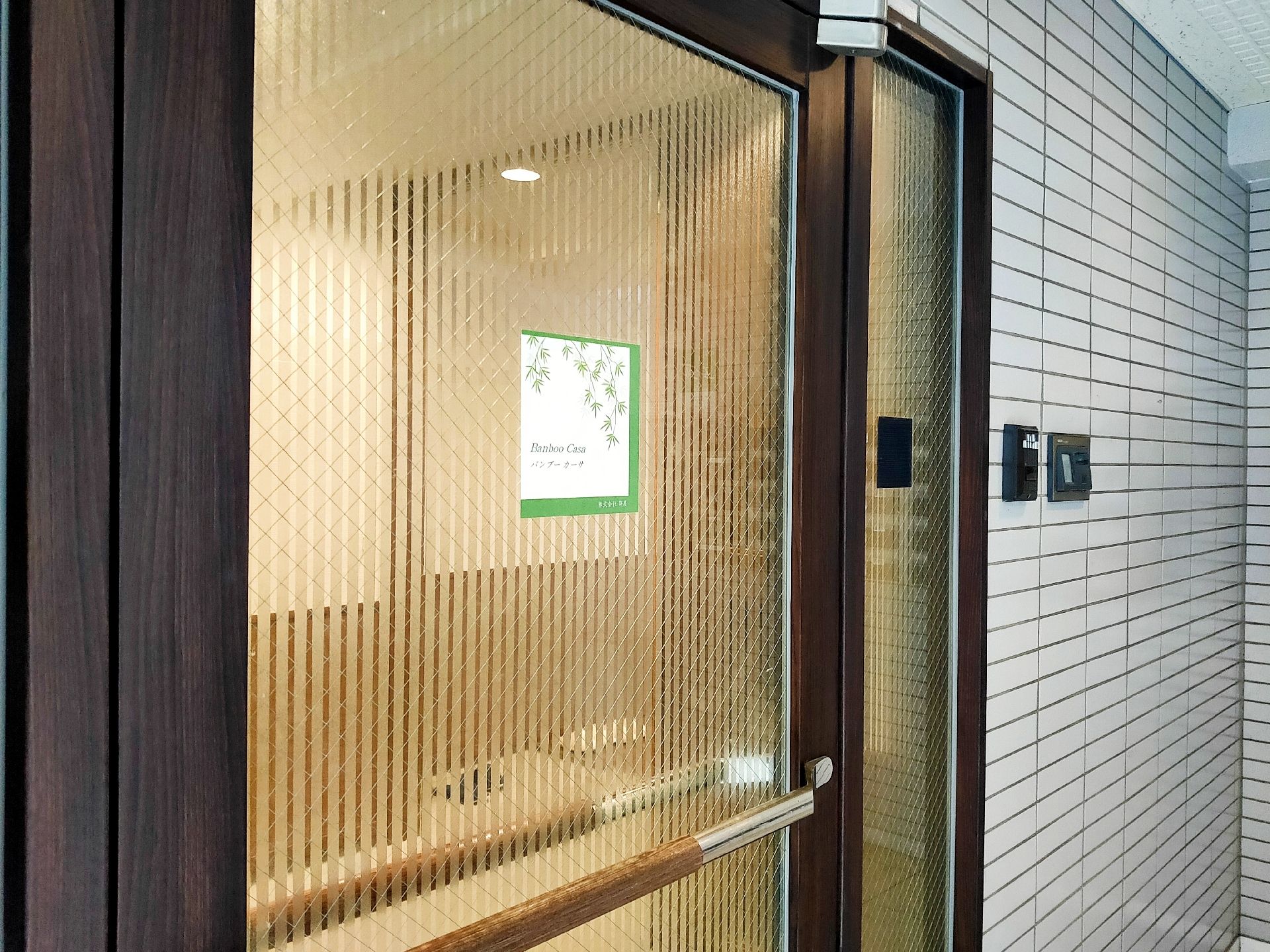 ガラスのドアが設置され、屋外の外壁にはインターフォンも付いている。ガラス戸なので内部が少し見える。