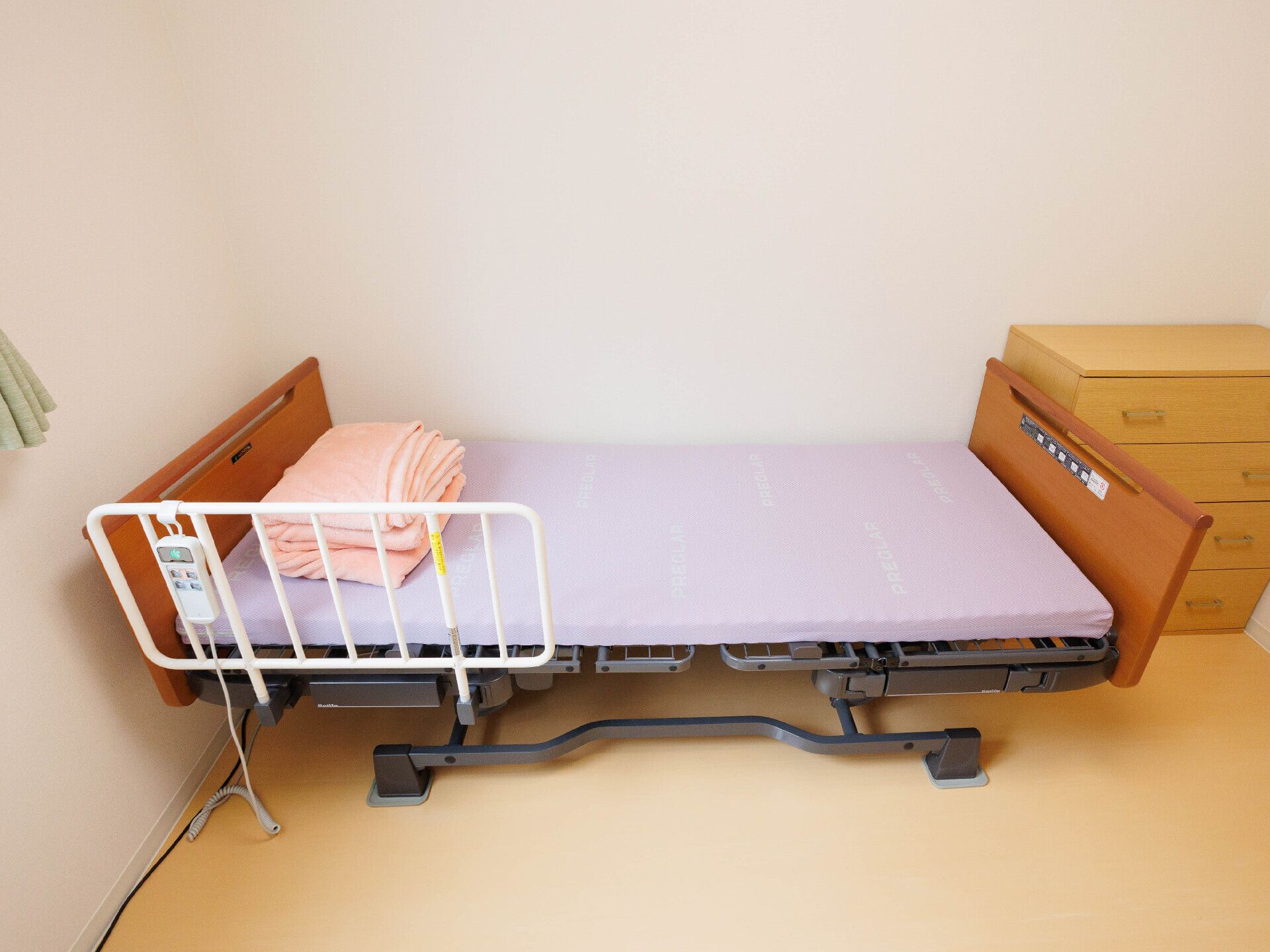 カメラに向かって笑顔を見せるスタッフと高齢者の女性。施設での何気ない一場面の様子