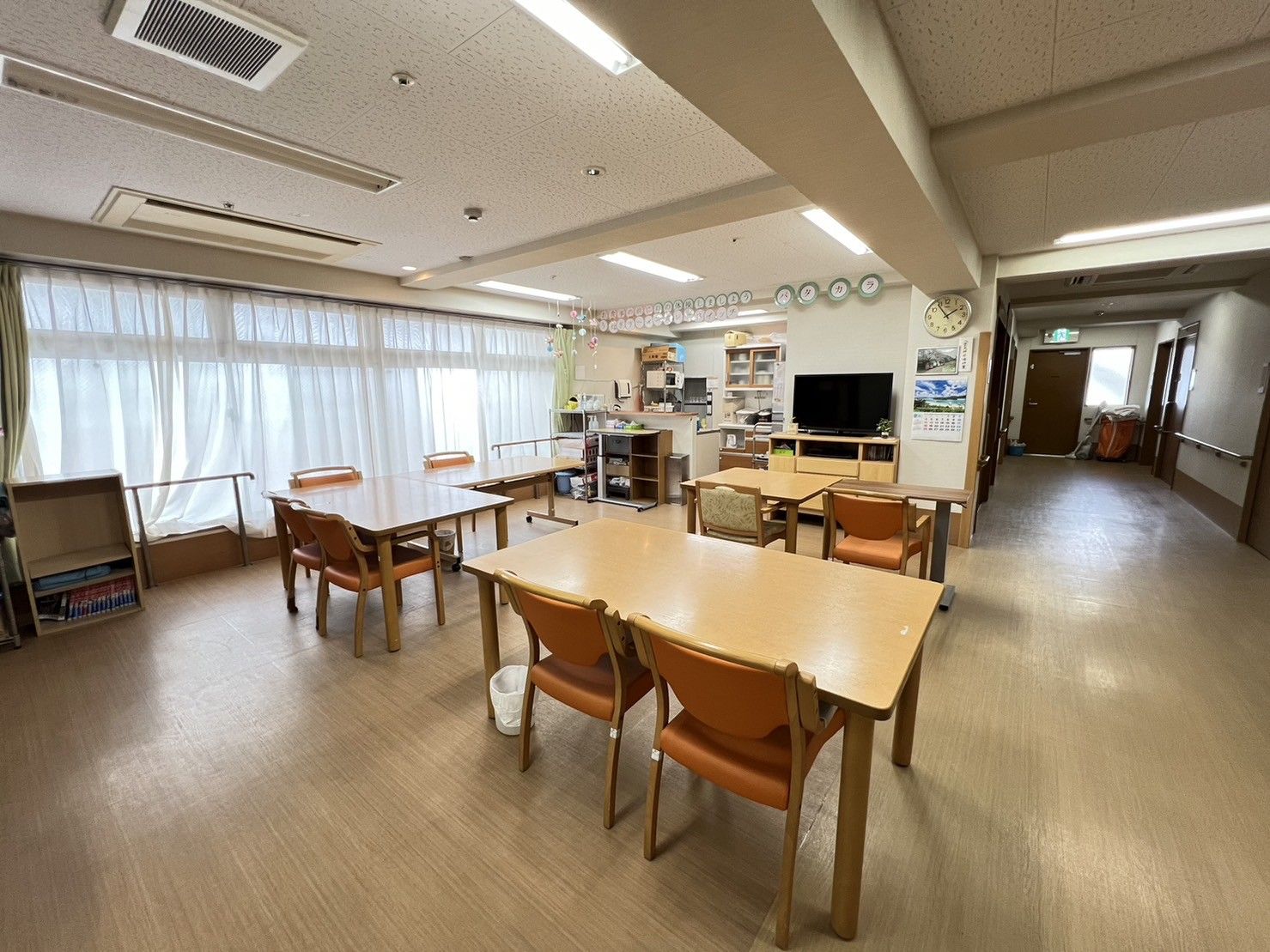 大きな窓が付いた食堂には4人掛けのダイニングテーブルセットが複数置かれ、明るい雰囲気。