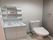 トイレと洗面所が同じ場所に設置され、トイレには温水便座、洗面所には棚や鏡がある。