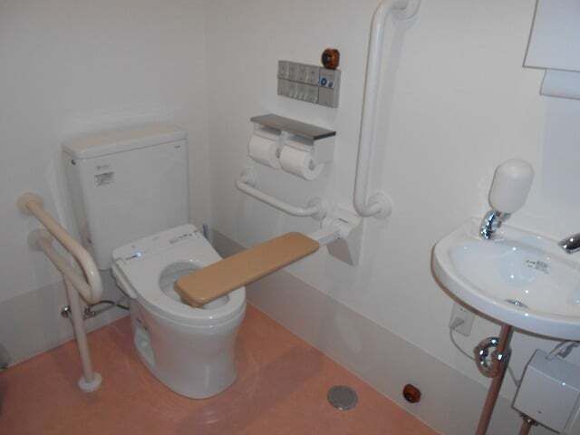 バーや手すり、呼び出しボタンなどが付いたトイレは広く、手洗い場もある。トイレの便座にふたはない。