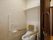 茶色いスライド式の扉を開けた先にあるトイレがある白い壁の部屋
