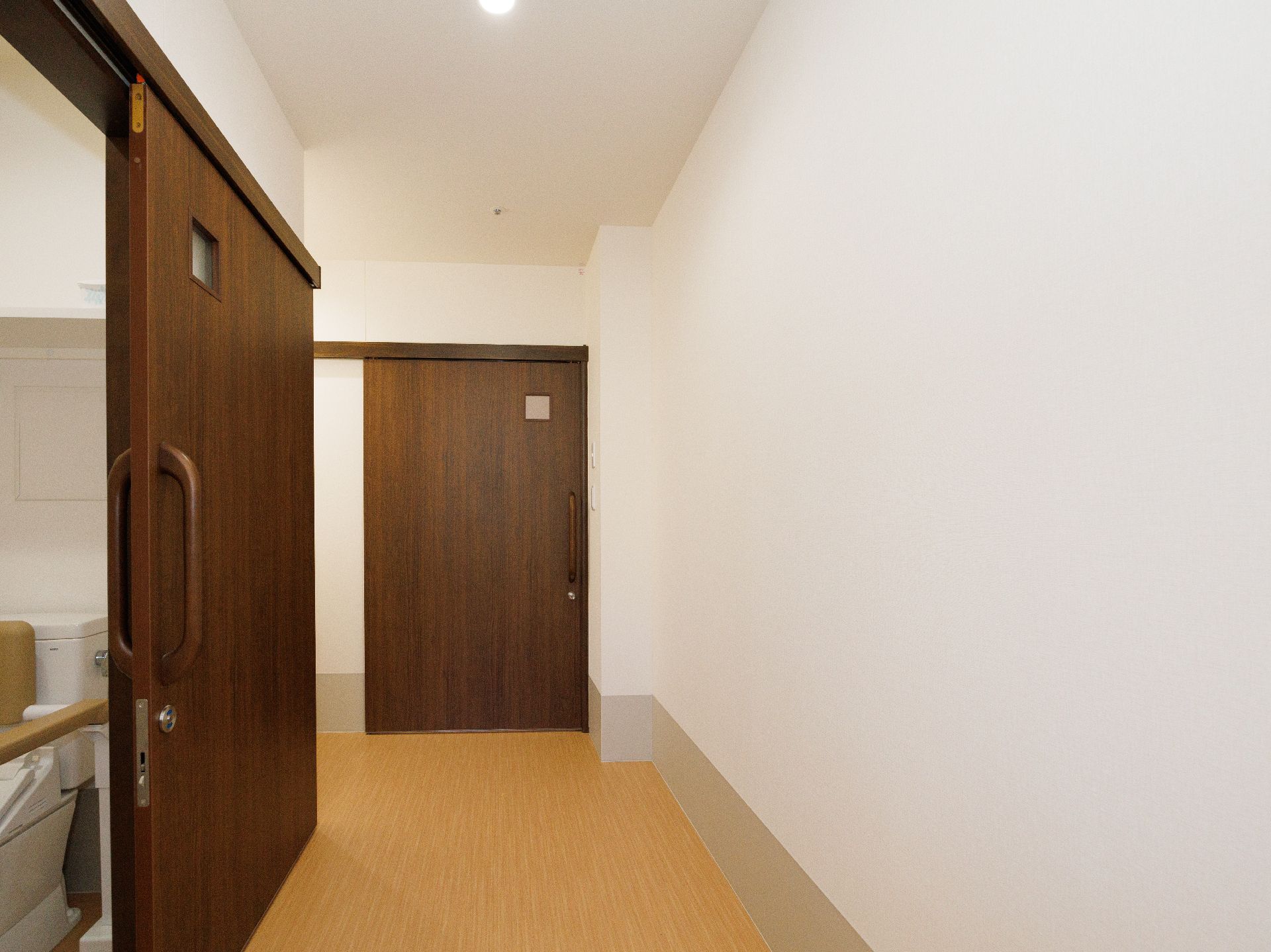 茶色い扉が付いた白い壁の部屋