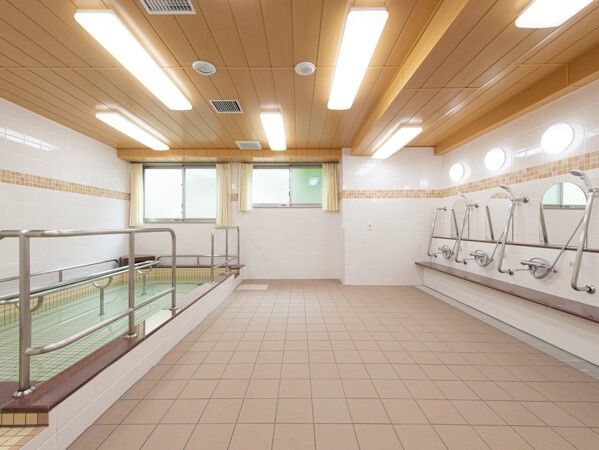 右側にはシャワースペース、左側にはたっぷりのお湯が張られている大きな浴槽があり、明るい雰囲気の大浴場。