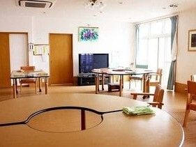 絵画が飾られた共有スペースには多くのデザインの異なるテーブルセットやテレビが置かれている。