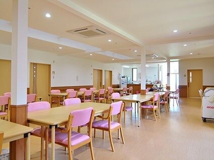 4人掛けのピンクの椅子がセットされたダイニングテーブルセットが複数設置された食堂は明るい雰囲気。