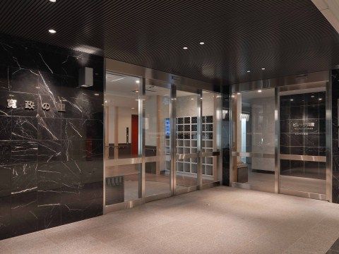 自動扉の左側の壁に施設名称がライトアップされている玄関