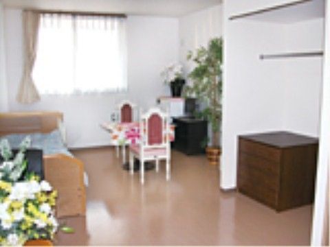 おしゃれなテーブルや椅子がベッドの横に置かれている居室
