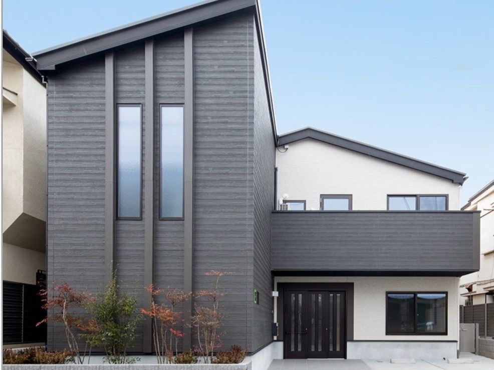 白とグレーの外壁で三角屋根の2階建てグループホーム
