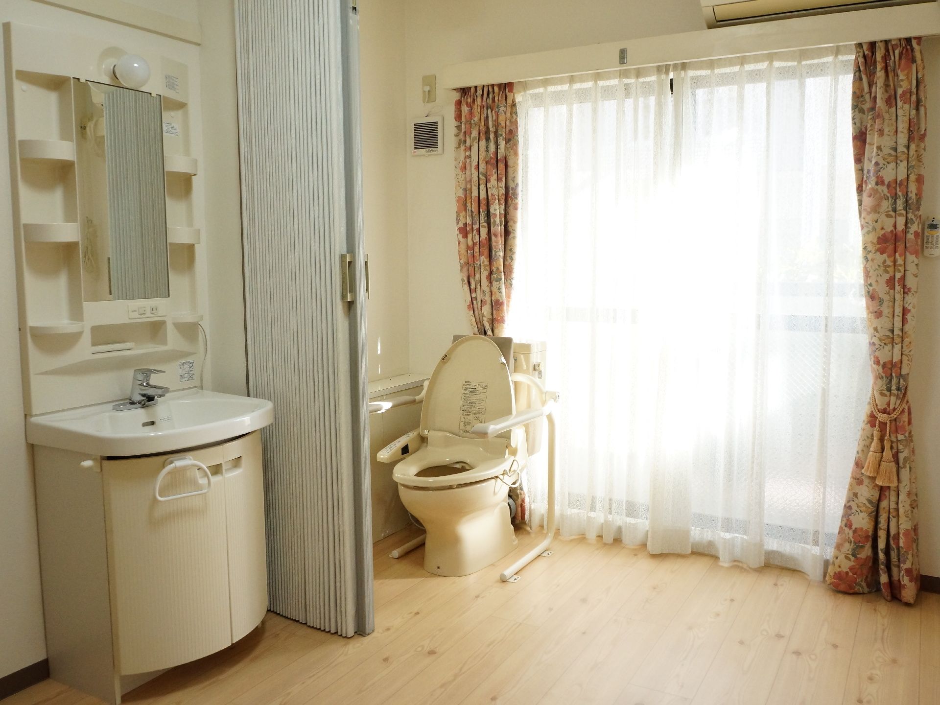 トイレと洗面所はパーティションを使って区切られている。トイレの背後には大きな窓があり、日光が差し込み明るい。