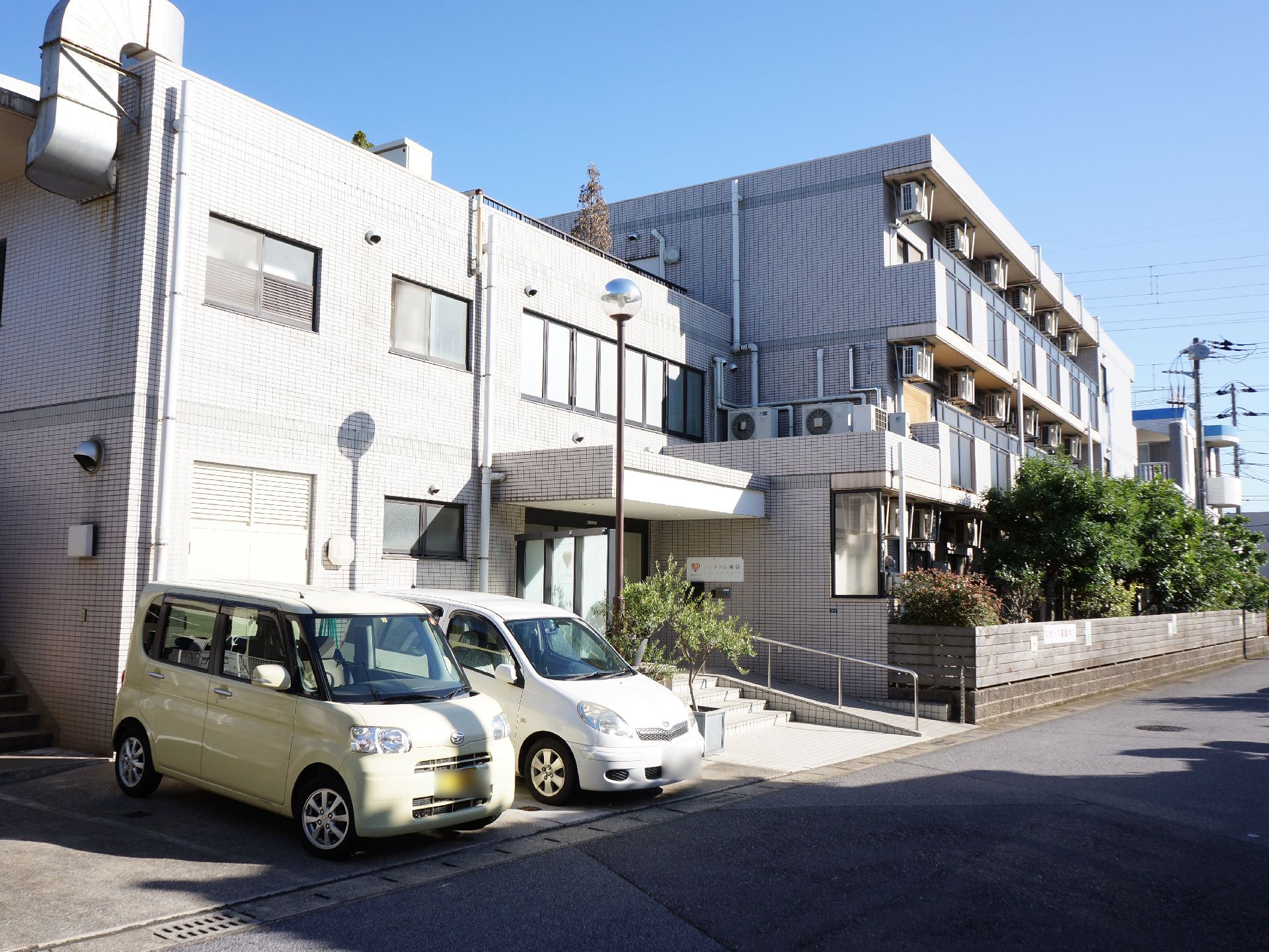 玄関前には数台分の駐車場があり、階段かスロープで玄関にアクセスできる。ドアの前にはひさしがあるため、雨の日に傘をゆっくり仕舞うことができる。