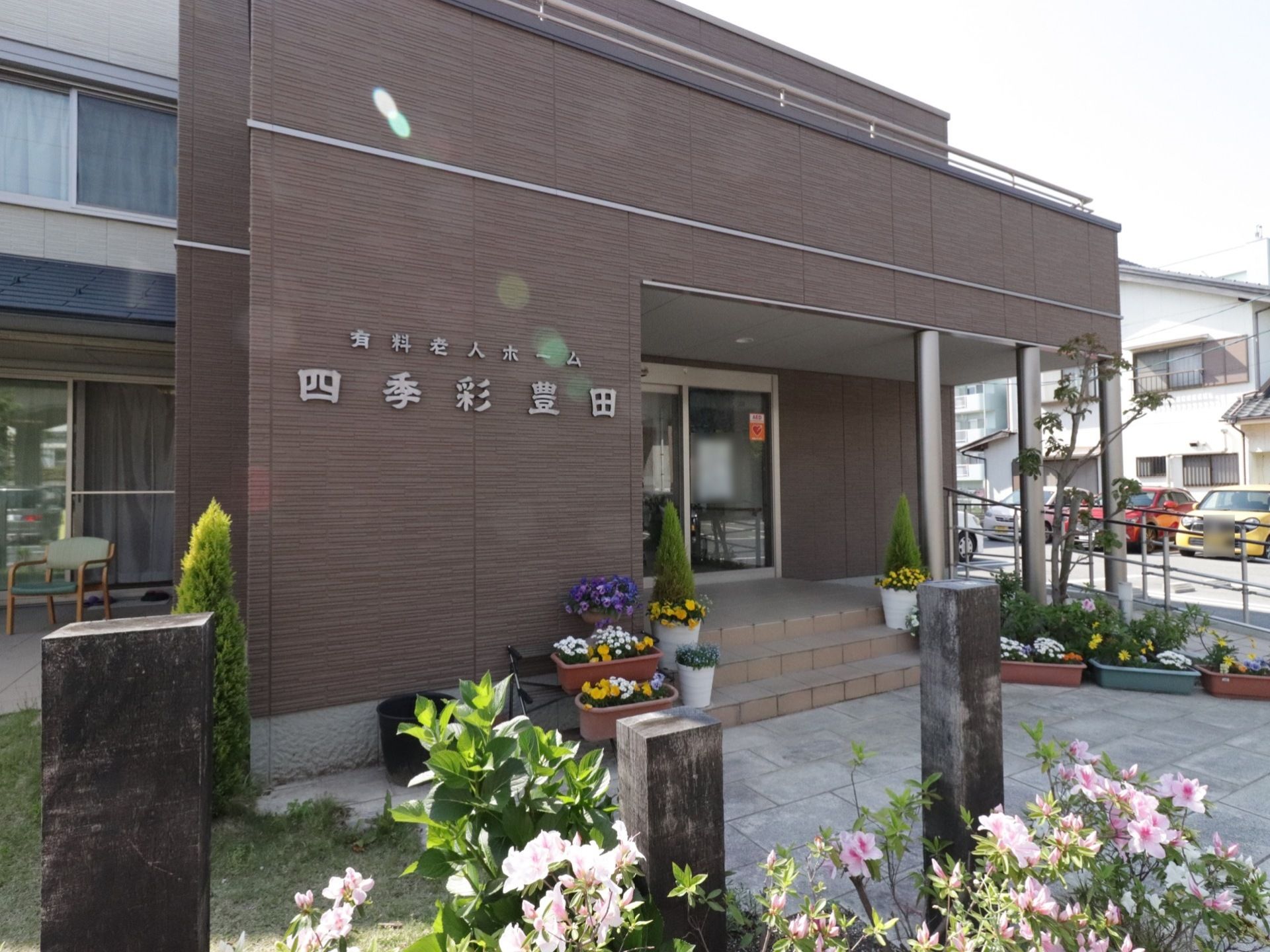玄関へ続く階段の両端に花鉢や植木が並んでいる。階段下は石畳みになっており、芝生のスペースと隣接している。