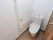 トイレの扉は、取っ手の大きな木製の引き戸である。温水洗浄便座があり、タンク上に手洗いがついている。棒状のタオル掛けが壁にある。