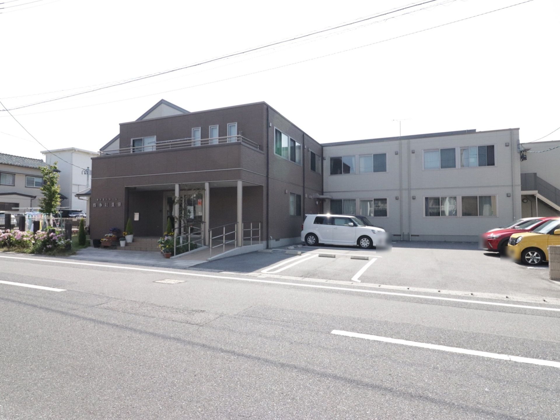 建物は2階建てである。L字型になっており、玄関がある棟の外壁は濃い茶色であり、もう一方はクリーム色である。
