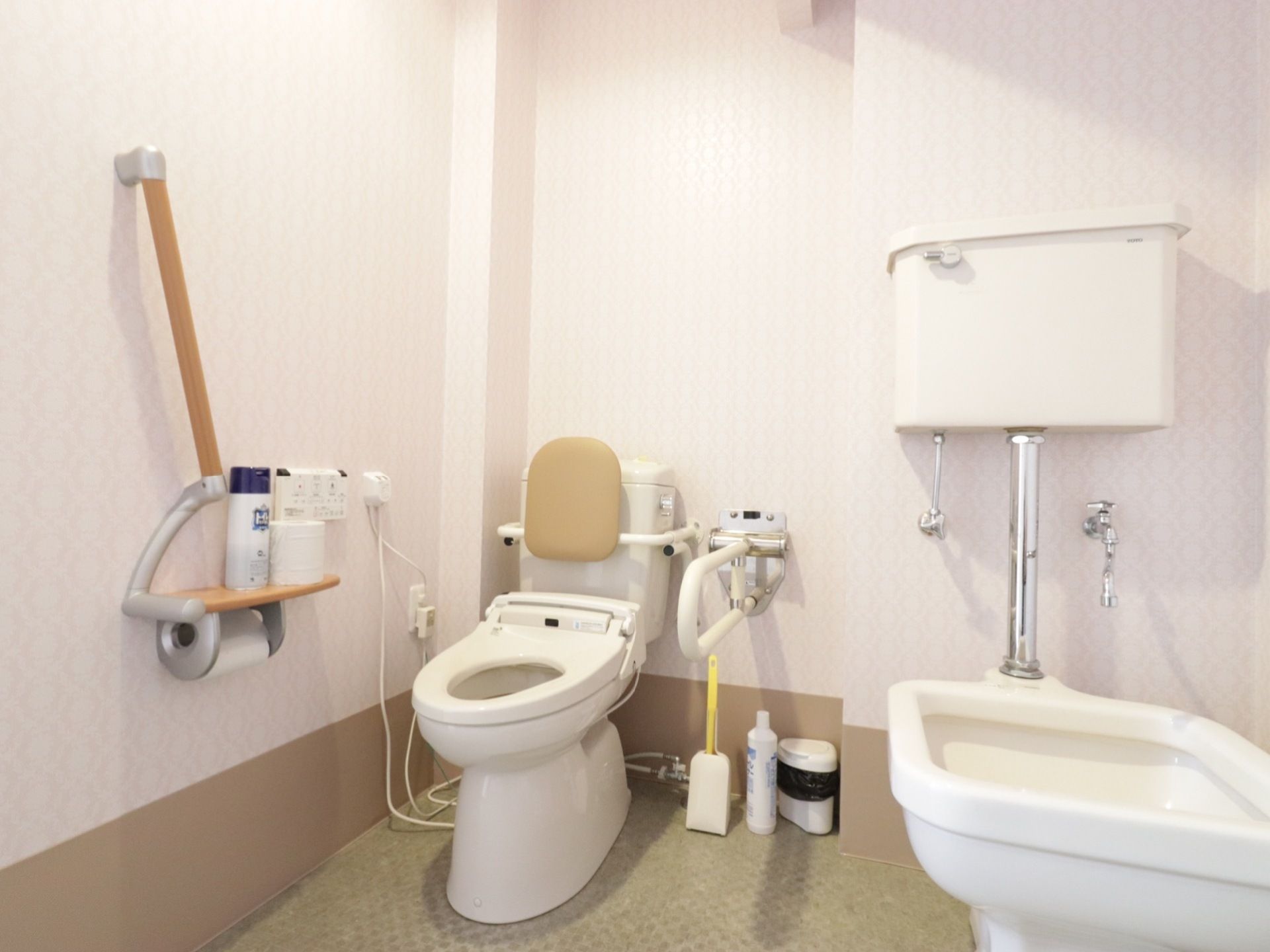 トイレはオストメイトに対応した器具も置いている。便座には、背もたれがつけてある。壁には斜め上に向いた手すりを設置している。