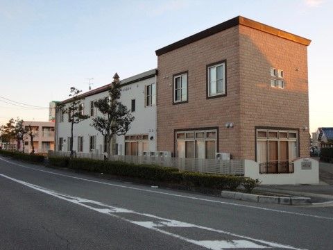 ２階建てのモダンな建物である。周辺は閑静な住宅街で、交通量の少ない道路に面している。車での移動が便利である。