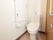 白を基調としたトイレで、とても清潔感がある。手すりと呼出しボタンが壁側についており、緊急の時も安心である。