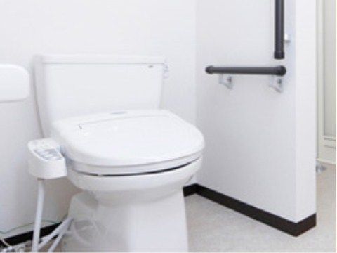 壁に手すりが設置された白い洋式トイレ