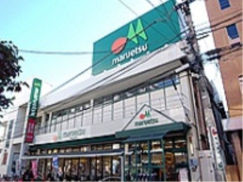 建物の上に大きな緑色の看板が設置されているスーパーの外観
