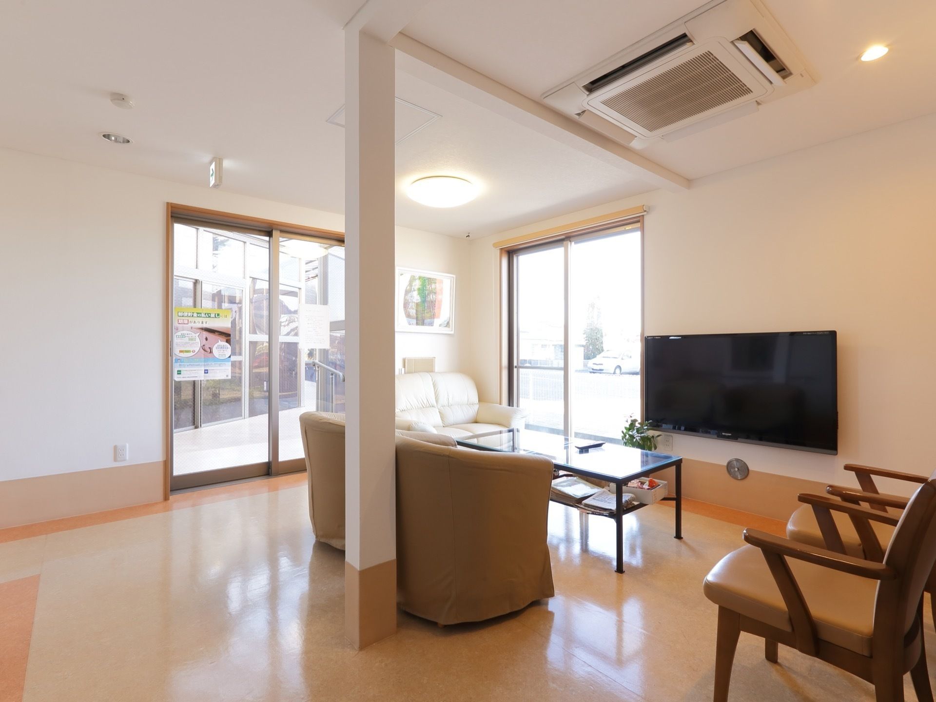 南側の窓から日差しが入る。エアコン、大型テレビが設置されており、空調の効いた部屋でのんびり過ごすことができる。