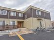 ２階建てのツートーンカラーの施設の様子。階段とスロープの脇には手すりが付いている。地面には点字ブロックも設置されている。