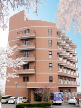 桜に囲まれた明るい外観