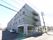 施設は通りから見て、奥に長い4階建ての建物。道路側にはベランダがあり、建物に沿って奥に1列の駐車スペースがある。