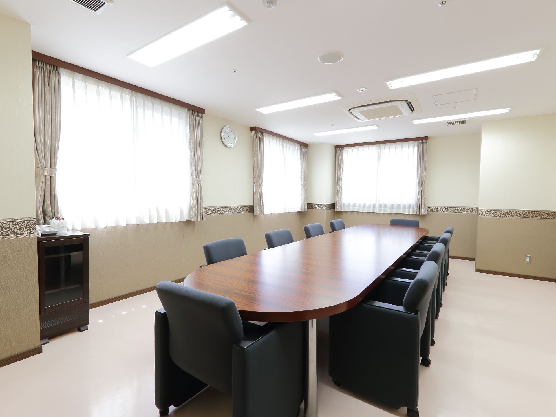 部屋はかなり広くシンプル。10人が座れる大きなテーブルと椅子があり、三つある窓からも日が差し明るい。