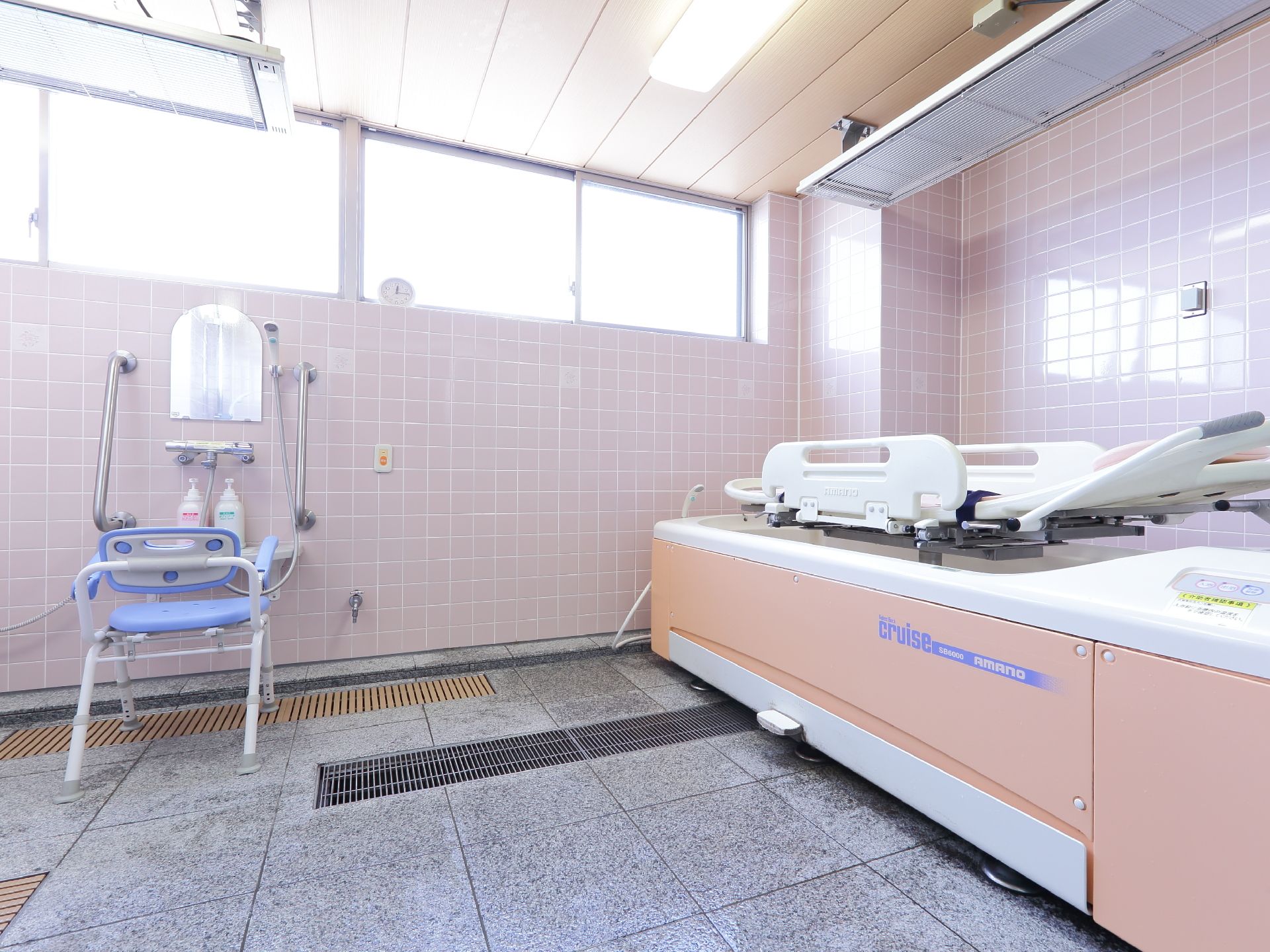 バスルーム右手には身体が不自由な入居者専用の介助用器具があり、上部には横になれるベッドが付いている。
