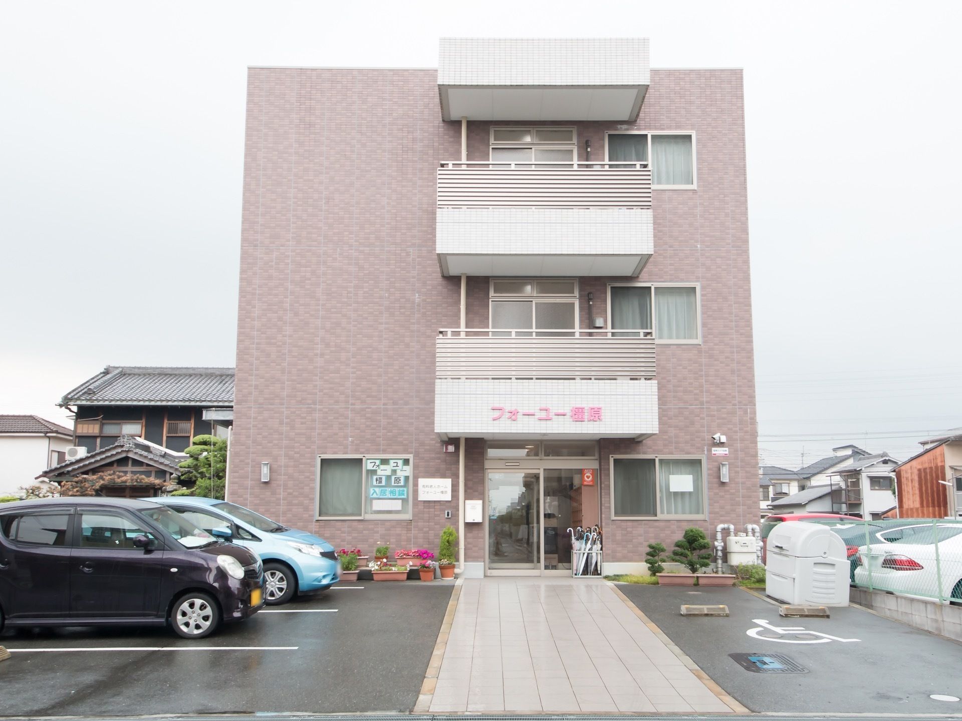 施設名の文字が見やすく、落ち着いた雰囲気の綺麗な建物。車椅子をご利用の方のための駐車スペースが用意されている。