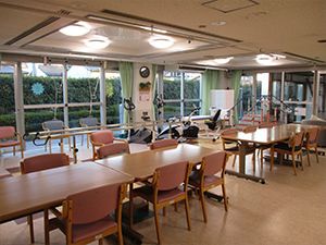 大きな窓が付いた食堂には木製のテーブルセットが並び、窓際には平行棒などが置かれている。