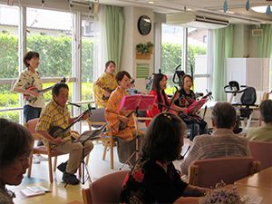 三味線のようなものを弾いている人たちの演奏を高齢者たちが熱心に聞いている。