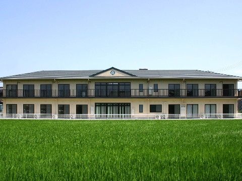 2階建ての建物周辺に、大きく広がった色鮮やかな芝生