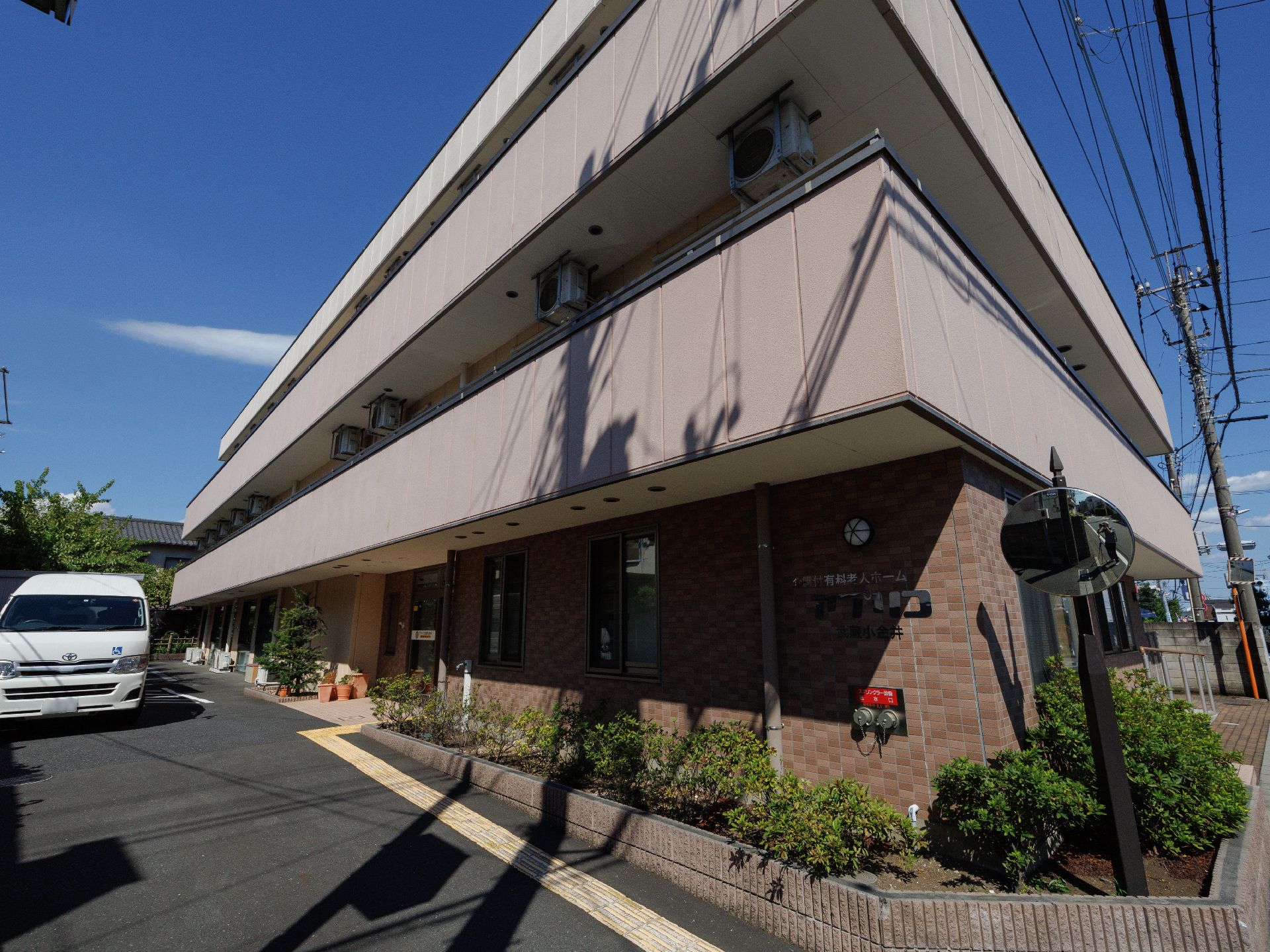 アスファルトに隣接したベージュの外観の建物