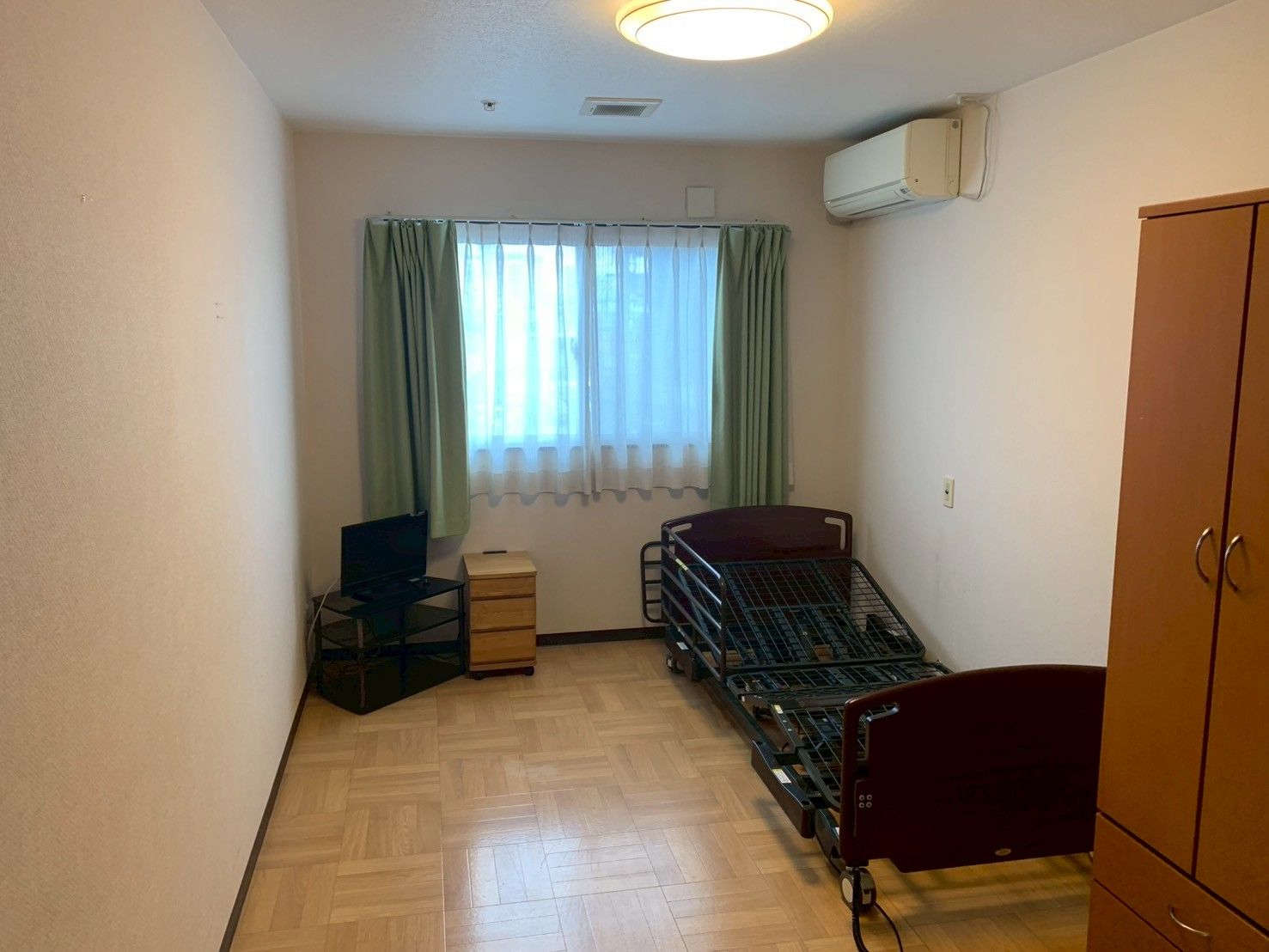 ボーダー柄のエプロンを付けた女性スタッフが白いシャツを着た高齢男性のサポートに当たっている。