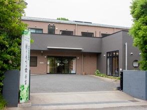 ぬくもりの家今富と書かれた看板と門がある、2階建てグループホーム