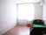 エアコンが付いたフローリングの部屋には介護用ベッドがあり、寝具は付いていない。大きな窓がある。