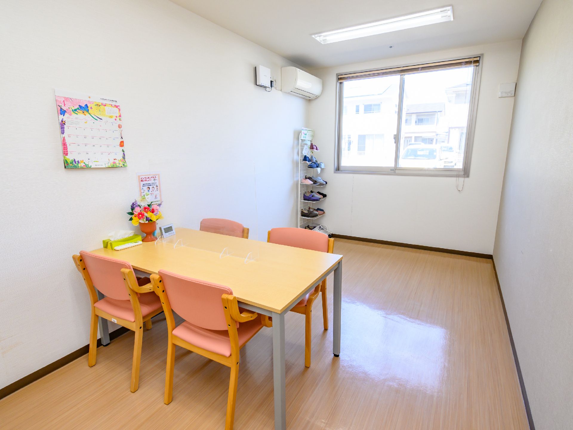 高齢者の方にタオルをかけてマッサージしているスタッフと振り返りながら会話する女性の様子