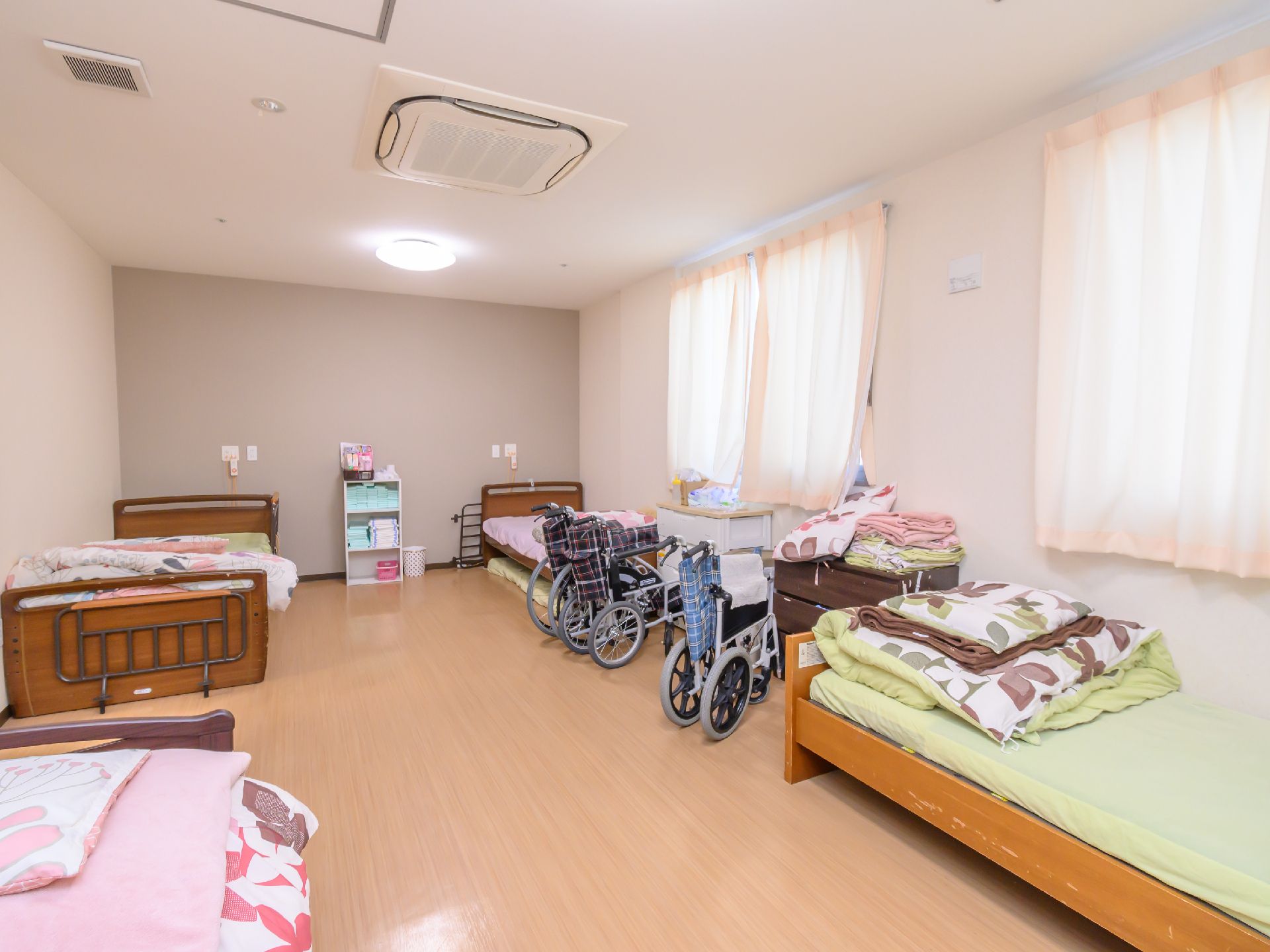 車いすに乗った女性を押す家族の男性とそこに寄り添う介護スタッフの様子