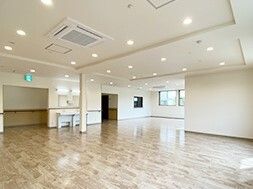 車いす対応の洗面所が付いた広い共有スペース。段差はなく、廊下との出入り口は幅広く作られている。