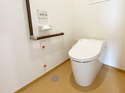 トイレはシンプルで操作パネルやエル字型の手すり、呼び出しボタンが設置されている。