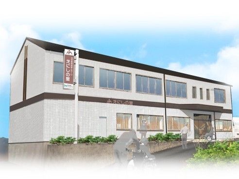 ブラウン系の２階建ての建物。玄関には車寄せがあり、建物の外壁にはホーム名が書かれ、周りには低木が植えられている。