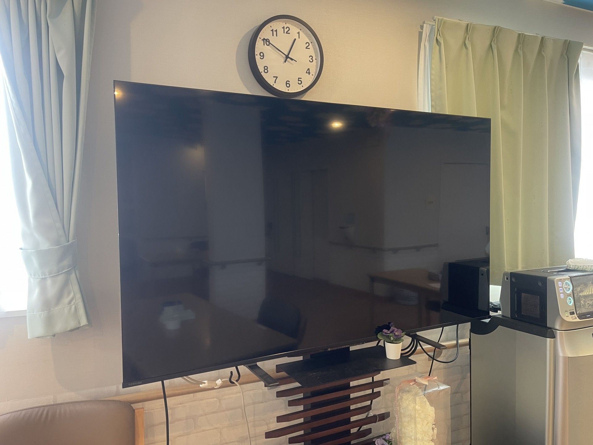 大きなテレビと時計の壁