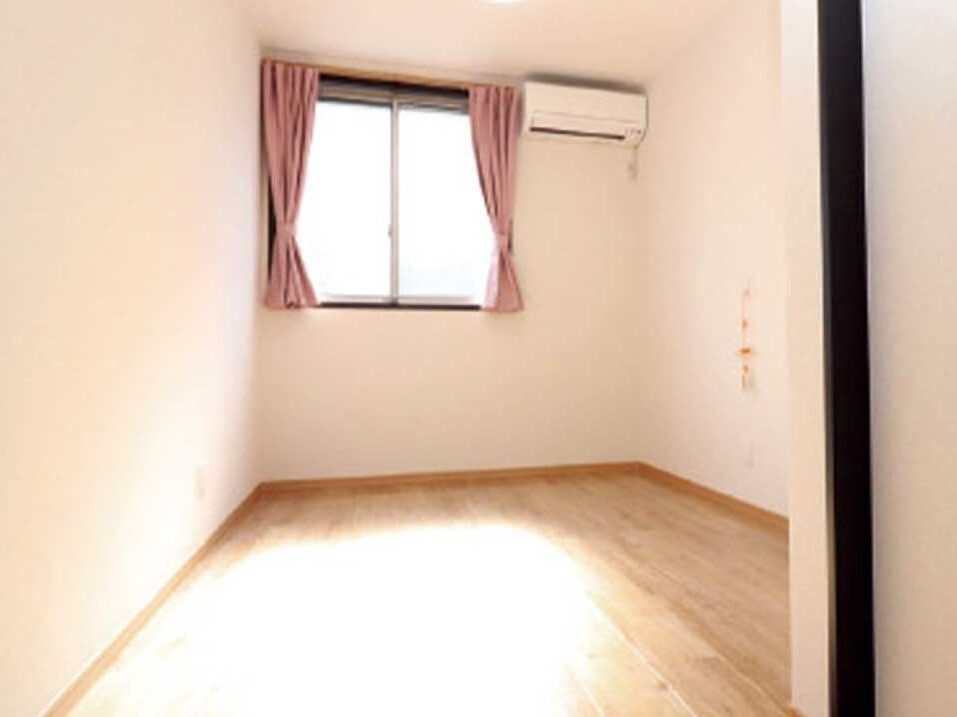 エアコンが設置されたフローリングの部屋には家具や家電はなく、壁には緊急通報装置が付いている。